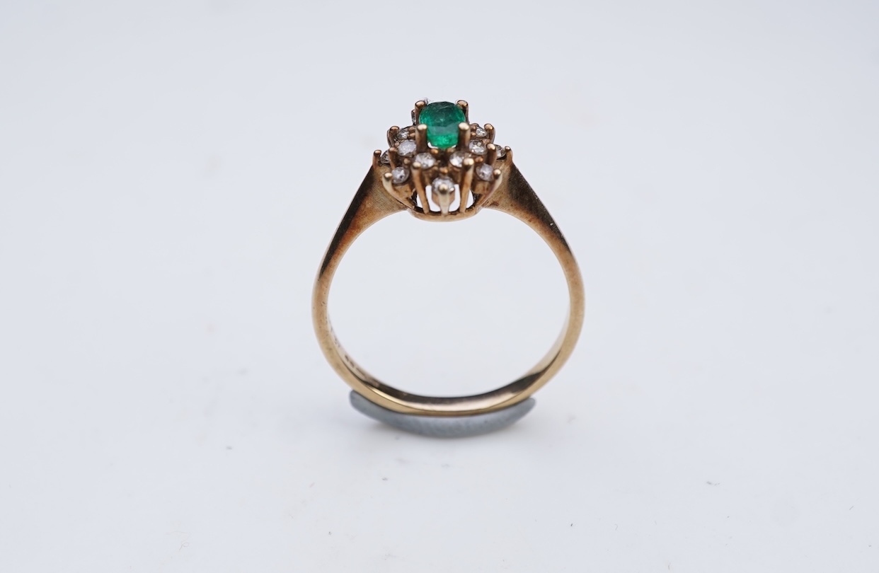 An emerald and diamond cluster ring